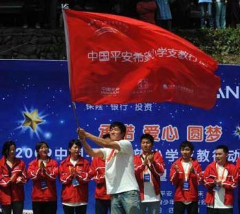 Chinese hurdler Liu Xiang waves a flag at a primary school in quake-hit Beichuan county, southwest China's Sichuan province, Monday May 11, 2009. (Xinhua Photo)