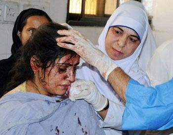 Pakistani paramedics give treatment to an injured woman at a hospital following a suicide blast in Darra Adam Khel. A suicide car bomber Monday killed 10 people at a paramilitary checkpoint in northwest Pakistan, where heavy fighting has sent more than 350,000 people fleeing in little more than a week. (AFP/Hasham Ahmed) 