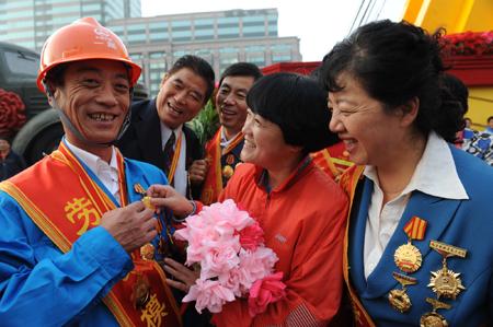 Role models from every walk of life of China gather in front of a float that will take part in the celebrations for the 60th anniversary of the founding of the People's Republic of China, in Beijing, capital of China, Oct. 1, 2009. (Xinhua/Tao Ming) 