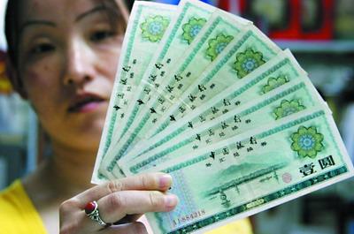 A woman holds up a sheaf of foreign exchange certificates (FECs), which were withdrawn from circulation on January 1, 1995 and the period for conversion ceased at the end of June 1995.