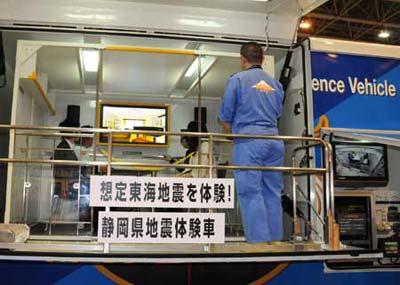 Visitors sit in a vehicle to experience a simulated quake during an exhibition of products and technologies that can be used to cope with earthquakes in Shizuoka, Japan, April 25, 2009. (Xinhua photo)