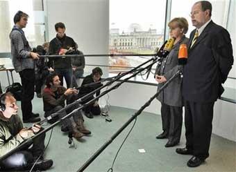 Chancellor Angela Merkel, left, and Finance Minster Peer Steinbrueck, right, give a statement in the Berlin Chancellery on Sunday, Oct. 5, 2008. 'We will not allow the distress of one financial institution to distress the entire system,' Merkel told reporters while talks between government and business leaders continued in the capital. 'For that reason, we are working hard to secure Hypo Real Estate.'(AP Photo)