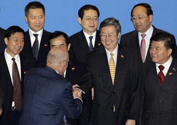 US Treasury Secretary Henry Paulson (front) shakes hands with Zhou Xiaochuan (2nd R), governor of the People's Bank of China, before the opening session of the fifth China-US Strategic Economic Dialogue in Beijing, Dec 4, 2008.[Agencies] 