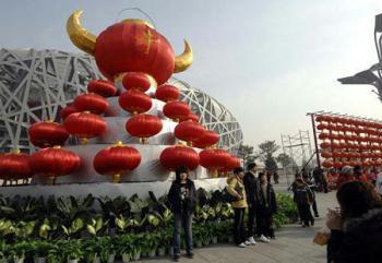 Tourists take photos in front of red lanterns that pile up as the head of an ox at the National Stadium, or Bird's Nest, on Thursday, January 29, 2009. (Xinhua Photo)