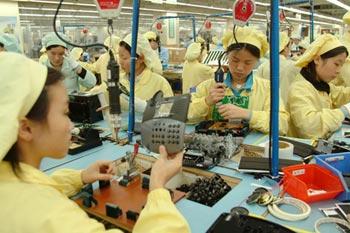 Workers at a factory in Dongguan assemble phone handsets. [Bloomberg News] 