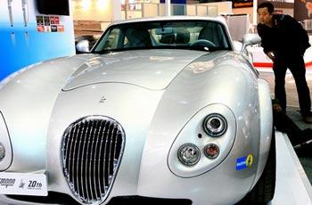 A worker takes a close look at a luxury sedan at the biennial Shanghai Auto Show which opens Monday to media and on Wednesday to the public, in Shanghai Sunday April 19, 2009. [Xinhua]