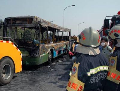 Firefighers and policemen investigate at the spot of a fire broke out on a public bus in Chengdu, capital of southwest China's Sichuan Province, June 5, 2009. A fire broke out on the bus, killed at least 24 people on Friday.(Xinhua/Xiao Lin)