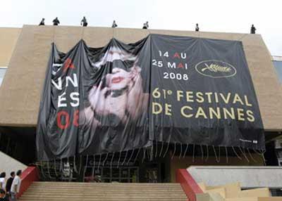 Workers on the roof of the Festival Palace use ropes to position a giant canvas of the official poster of the 61th Cannes Film Festival in Cannes May 12, 2008. Cannes film festival, the world's biggest, runs from May 14-25.  (Xinhua/Reuters Photo)