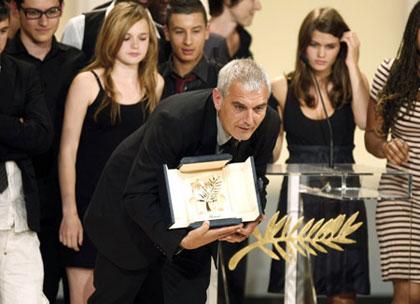 French director Laurent Cantet (C) is surrounded by students as he shows the Palme d'Or award for his film 