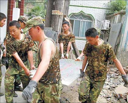 Soldiers carry a stone monument out of Bao'en Temple Thursday, May 29, 2008. (Photo: China Daily)