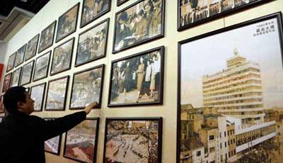 A man stands before the old photos of an exhibition featuring China's 30 years' reform and opening-up in southwest China's Chongqing Municipality Dec. 14, 2008.(Xinhua Photo)