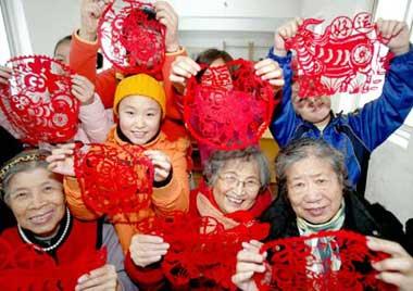 Residents show paper-cuts made by themselves to mark the coming Year of Ox in Chinese lunar calendar, at Siping Street Community in Shenyang, capital of northeast China's Liaoning Province, Dec. 27, 2008. (Xinhua/Zhang Wenkui)