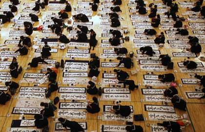 School girls in uniform participate in a New Year calligraphy contest in Tokyo January 5, 2009. About 3,000 calligraphers, who qualified in regional competitions throughout Japan, took part in the contest to celebrate New Year. [Agencies] 