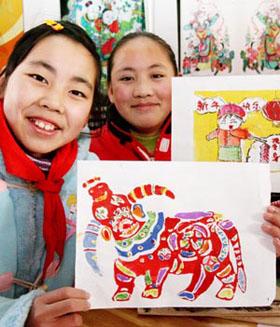 Two girls shows their handmade Taohuawu woodcut New Year paintings in Taowu Central Elementary School in Suzhou, east China's Jiangsu Province, Jan. 14, 2009. An activity with the theme of greeting the Chinese Year of Ox was held here during which pupils made Taohuawu New Year paintings and presented to their parents, friends and teachers. (Xinhua/Wang Jianzhong)