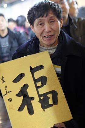 Wang Wanlin, who has helped more than 300 waifs, shows a calligraphy work of "fu", meaning "good wishes", during a calligraphy activity held in Hangzhou, capital of east China's Zhejiang Province, Jan. 15, 2009, to greet the Chinese lunar New Year starting from Jan. 26. (Xinhua/Cheng Ruixin)