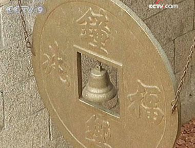 People throw coins to strike a lucky bell.