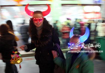 Holding a cartoon ox lantern in hand and wearing colorful toy ox horns, a mother and her son happily walk along Zhongshan Street in Nanchang, east Jiangxi province on Wednesday, February 4, 2009. Since 2009 is the Chinese lunar Year of Ox, a variety of ox lanterns are being purchased by locals, who are preparing for the traditional Lantern Festival which falls on the 15th day of the 1st month on the Chinese lunar calendar. [Photo: jxnews.com.cn]