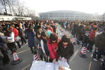 Job hunters receive materials with job vacancy information at a job fair in Beijing, on Feb. 5, 2009. Nearly 4,000 positions are offered by more than 300 companies at the job fair on Thursday. (Xinhua/Xing Guangli)