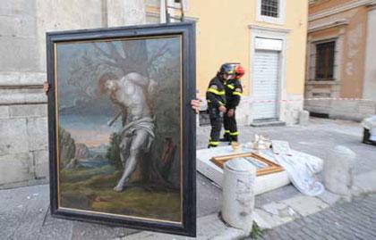 A rescuer holds a painting retrieved from the damaged Santa Maria Church in the old city of L'Aquila, Italy, on April 7, 2009. Rescuers were trying to save artifacts from buildings devastated in a strong quake that claimed 235 lives so far in central Italy. (Xinhua/Wu Wei)