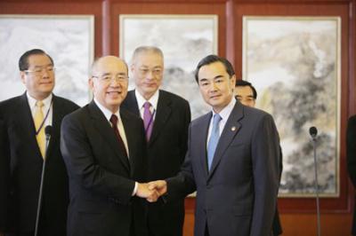 Wang Yi (R, Front), director of the State Council Taiwan Affairs Office, shakes hands with Kuomintang (KMT) Chairman Wu Poh-hsiung at the Beijing Capital International Airport in Beijing on May 25, 2009. A KMT delegation headed by Wu arrived in Beijing on Monday for an visit on the mainland. (Xinhua/Xing Guangli)