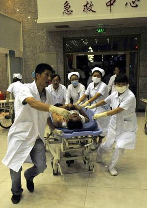 An injured man is carried to an urgent care center in Urumqi, capital of northwest China's Xinjiang Uygur Autonomous Region on July 5, 2009.(Xinhua/Shen Qiao)