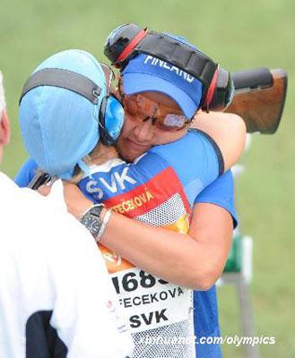 Satu Makhela-Nummela of Finland, the gold winner of trap shooing, hugs Slovakia's Zuzana Stefecekoa, the silver winner at the victory time. (Xinhua)