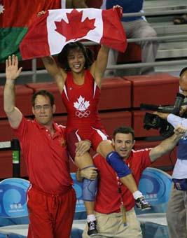 Carol Huynh of Canada (C) celebrates victory after winning over Icho Chiharu of Japan during the women's freestyle 48kg final at the Beijing 2008 Olympic Games wrestling event in Beijing, China, Aug. 16, 2008. Carol Huynh won the bout and got the gold medal.(Xinhua Photo)