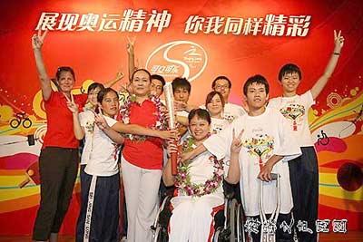 Han (fourth L) poses with a group of disabled students of Beijing Third School for the deaf on Monday.[vos.com]