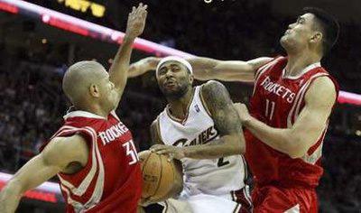 Cleveland Cavaliers Mo Williams (C) attempts to put up a shot while defended by Houston Rockets Shane Battier (L) and Yao Ming (R) during the third quarter of their NBA basketball game in Cleveland, December 23, 2008.REUTERS/Aaron Josefczyk (UNITED STATES) 