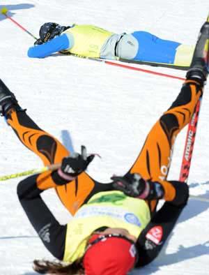 Skiers rest themselves on the ground after crossing the finish line during the women's Pursuit without a break of Cross-Country skiing in the 24th World Winter Universiade at the Yabuli Ski Resort 195km southeast away from Harbin, capital of northeast China's Heilongjiang Province, Feb. 23, 2009. (Xinhua/Gesang Dawa)