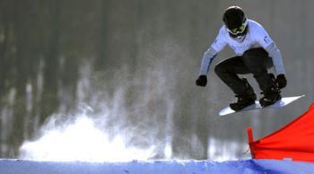 Russia's Vitaly Kartsev competes during the qualifications of men's snowboard cross in the 24th World Winter Universiade at the Maoershan Ski Resort, 85km southeast from Harbin, capital of northeast China's Heilongjiang Province, Feb. 20, 2009. Vitaly Kartsev took the 11th place after the qualifications with 1:01.73. (Xinhua/Li Ga)