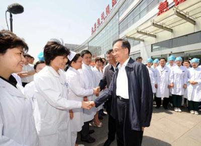 Chinese Premier Wen Jiabao (R) and Vice Premier Li Keqiang (2nd R) shake hands with medical staff of Beijing Ditan Hospital in Beijing, capital of China, May 17, 2009. Wen Jiabao and Li Keqiang on Sunday visited Beijing's first diagnosed A/H1N1 flu patient and medical staff at Beijing Ditan Hospital, and inspected the Chinese Center for Disease Control and Prevention. (Xinhua/Rao Aimin)