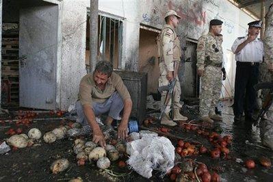 A merchant collects vegetables after a bomb exploded at a market in the Dora neighborhood of Baghdad, Iraq, Monday, April 1, 2009. Four people were killed and 14 others wounded in the blast, Iraqi police officials said.(AP Photo/Loay Hameed) 