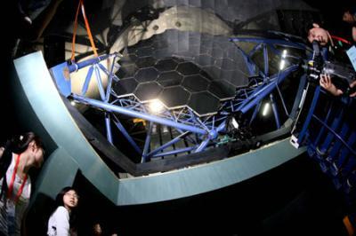 Visitors look at a part of the Large Sky Area Multi-Object Fiber Spectroscopy Telescope (LAMOST) in Xinglong, Hebei Province, north China, June 4, 2009.(Xinhua/Wang Yongji)