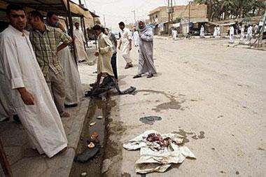 Iraqis gather near bloodied clothes following a car bomb blast in the southern city of Nasiriyah.(AFP/Essam al-Sudani)