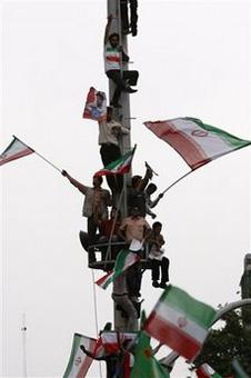 Supporters of the President Mahmoud Ahmadinejad stand on a mast during a rally to celebrate his victory in Friday's election, in Tehran, Iran, Sunday, June 14, 2009.(AP Photo/Vahid Salemi)