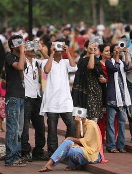 Bangladeshis watch the solar eclipse through specially-designed viewing material in Dhaka, Bangladesh, Wednesday, July 22, 2009. The longest solar eclipse of the 21st century pitched a swath of Asia from India to China into near darkness Wednesday as millions gathered to watch the phenomenon. (AP Photo/Pavel Rahman)