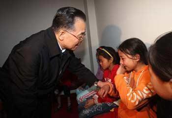 Chinese Premier Wen Jiabao comforts the children who lost their relatives in the powerful earthquake in Mianyang on May 13, 2008.(Xinhua Photo)