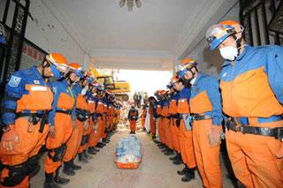 Members of the Japanese rescue team mourn for a victim at Qiaozhuang Town of Qingchuan County in the quake-stricken southwest China's Sichuan Province, May 17, 2008. Japanese earthquake rescuers found two corpses in a collapsed six-floor building in Qiaozhuang at 7:25 am after 16 hours rescue operation. (Xinhua/Li Tao)