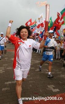 Torchbearer Zhang Xiaodong runs with the torch during the 2008 Beijing Olympic Games torch relay in Qingdao city, east China's Shandong Province, on July 21, 2008.