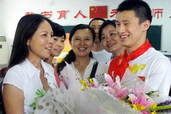 Chinese diver Zhou Luxin, silver medalist of Men's 10m Platform diving of the Beijing Olympic Games, presents a bunch of flowers to his teacher at Huanchengxilu Primary School in Wuhu City, east China's Anhui Province, Sept. 8, 2008. As the Chinese Teacher's day approaches, Zhou Luxin went to the school where he graduated to visit his teachers. (Xinhua/ Chen Lixi)