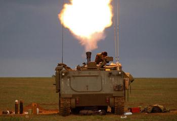 An Israeli soldier covers his ears after firing a mortar mounted on an armoured personal carrier (APC) towards Gaza from its position outside the northern Gaza Strip January 9, 2009.(Xinhua/Reuters Photo)