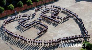 Pupils in Leping No.1 Elementary School in Jiangxi Province stand in circle to form a Charriol with 5.12 in it in order to commemorate the Sichuan earthquake on May 12 last year. (Xinhua Photo)