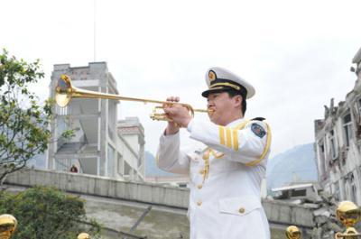 A man plays a trumpet at the beginning of the ceremony to mark the first anniversary of May 12 Earthquake in Yingxiu Township of Wenchuan County, southwest China's Sichuan Province, May 12, 2009. (Xinhua Photo)