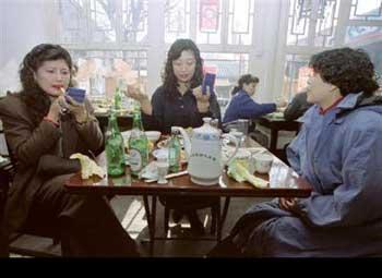 25 février 1994 : des femmes en train de se refaire une beauté après avoir déjeuné dans un restaurant de Beijing. A cette époque, « Aller au restaurant » était synonyme d'aisance, et, « avoir les lèvres rouges », de maquillage.