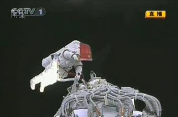 Esta imagen del 27 de septiembre de 2008 muestra al astronauta chino Zhai Zhigang ondeando una bandera china al exterior del módulo orbital de la aeronave Shenzhou VII. 