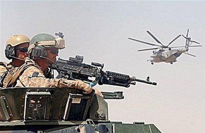 US Marines of the 2nd Marine Expeditionary Brigade keep watch as a CH-53 helicopter flies past during a patrol in Garmsir district of Helmand province.(AFP/Shah Marai)