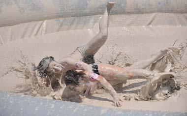 Two females are entangled in dogfight during a distinctive Women's Mud Wrestling Match, as some 40 female contestants from both China and overseas take part in this very amusing sport with the skin-friendly slurry and mud from the deep sea, in Wuhan, central China's Hubei Province, May 3, 2009. (Xinhua/Dong Yushan)
