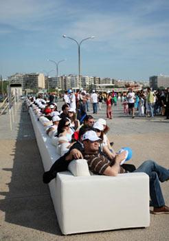 People sit on a super-long sofa in Thessaloniki, Greece, May 9, 2009. This 64.75-meter-long sofa set the Guinness World Records for being the longest sofa in the world. (Xinhua/AFP photo)