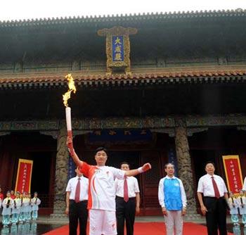 The Olympic torch relay kicks off in the Confucius Temple, Qufu City, east China's Shandong Province on July 22, 2008. The first torchbearer Kong Peng (front) holds the Olympic torch.((Xinhua Photo)